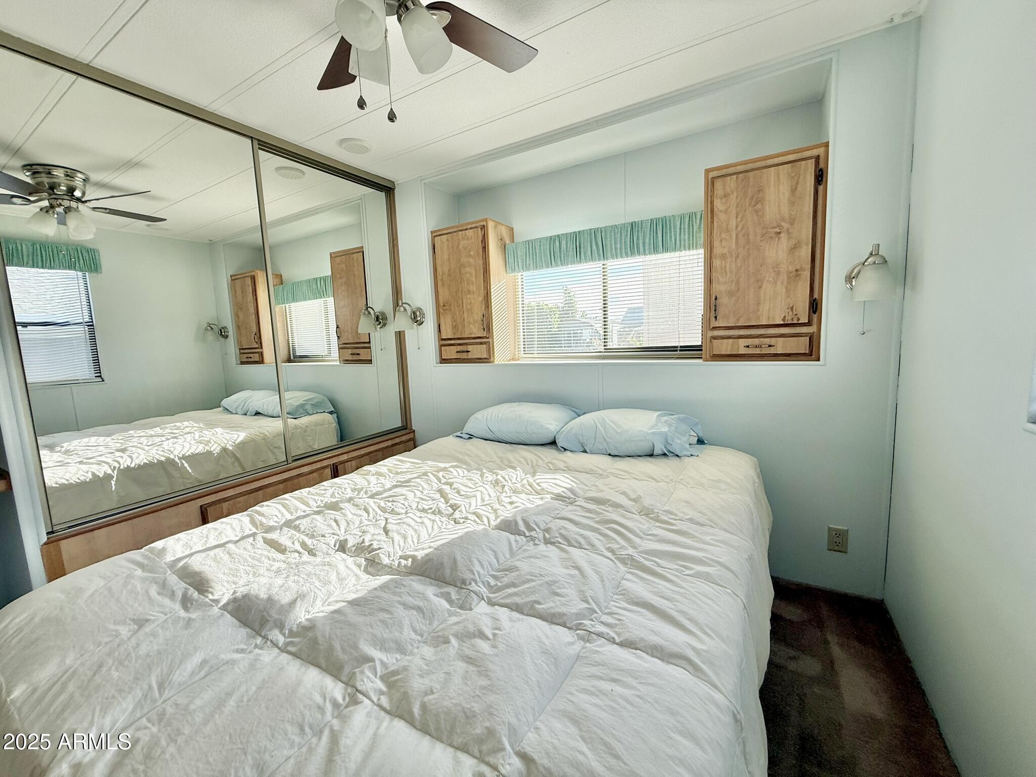 8865 East Baseline Road, Unit 1643 Mesa, AZ 85209 - Photo 5 of 44 a bedroom with a large bed and a chandelier