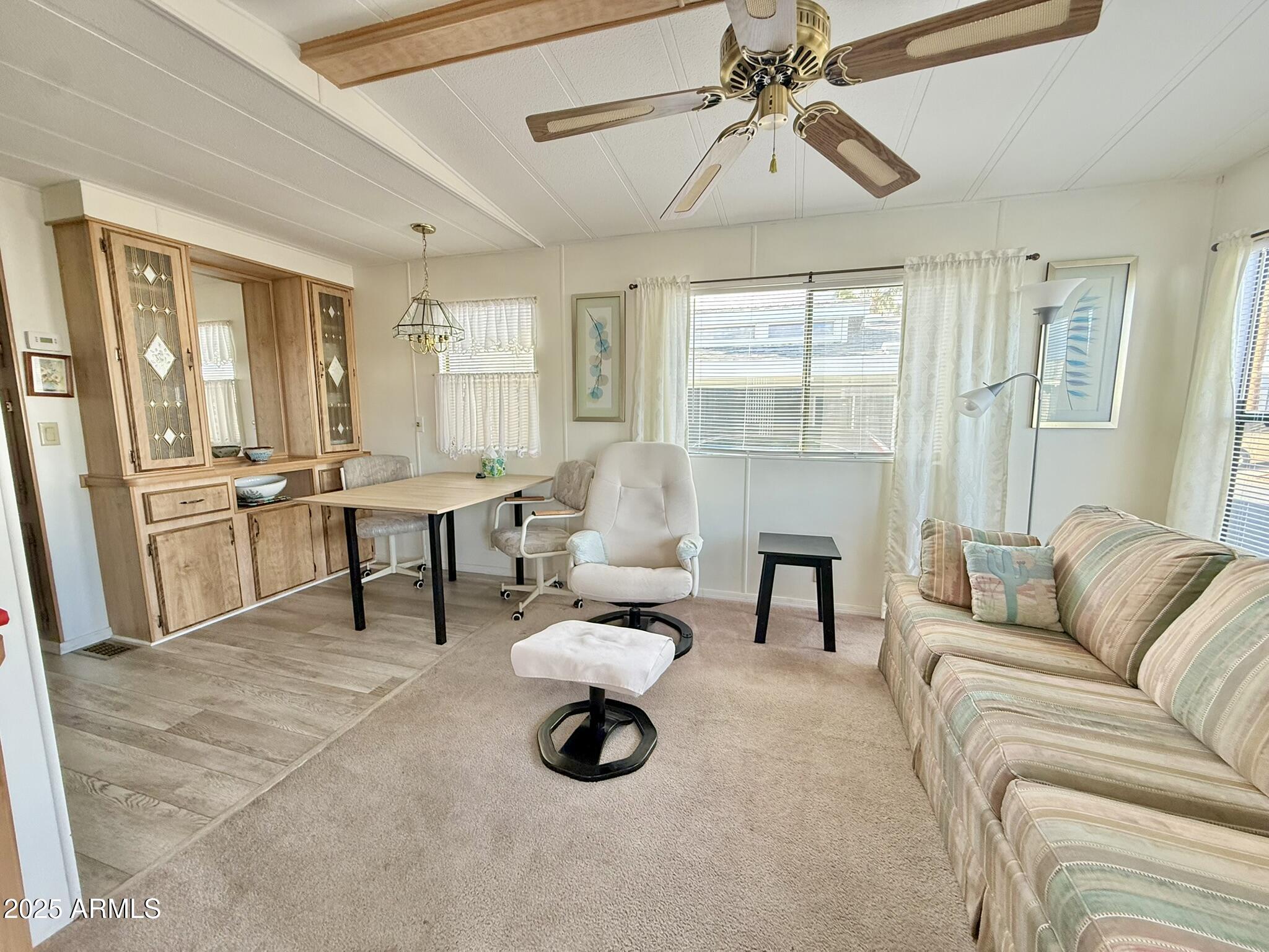 8865 East Baseline Road, Unit 1643 Mesa, AZ 85209 - Photo 7 of 44 a living room with furniture a dining table and a chandelier