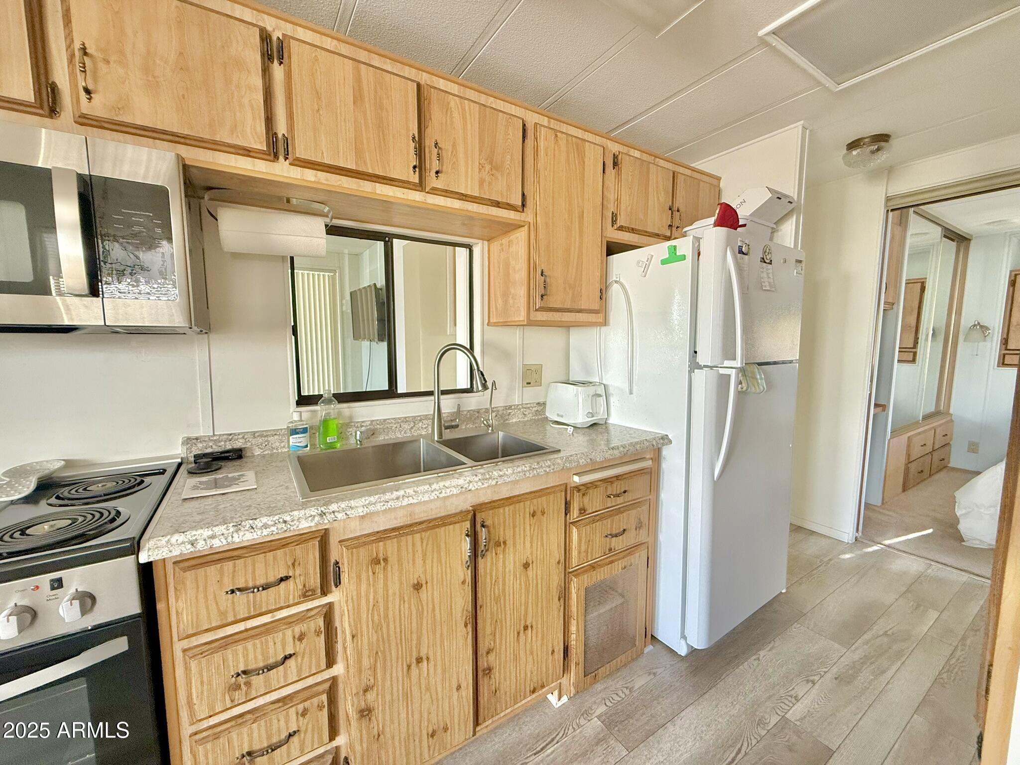 8865 East Baseline Road, Unit 1643 Mesa, AZ 85209 - Photo 9 of 44 a kitchen with granite countertop a sink stove and refrigerator