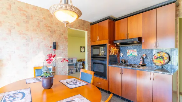 a kitchen with stainless steel appliances granite countertop a stove a sink and a dining table
