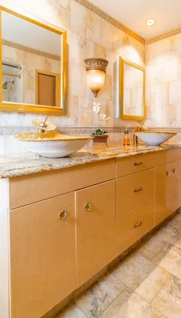 a bathroom with a granite countertop tub sink and mirror