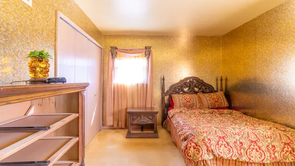 a bedroom with a bed a dresser and mirror