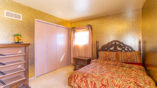 a bedroom with a bed and blue chair