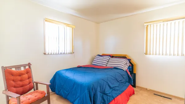 a blue bed sitting in a bedroom next to a window