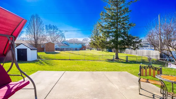 a view of a patio with table and chairs with wooden floor and fence