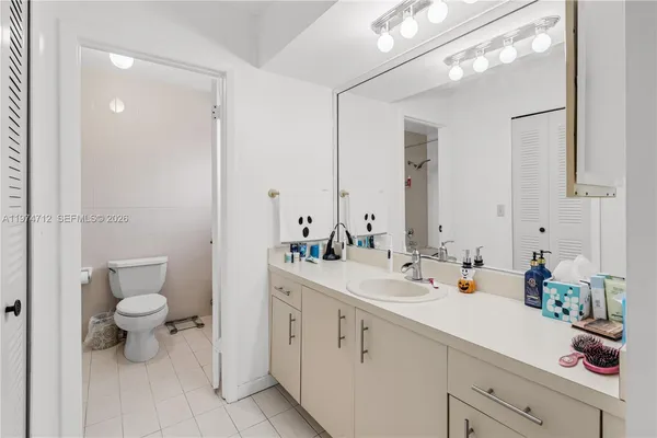 a view of bathroom with a sink mirror and toilet