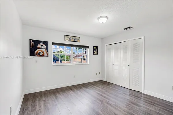 a view of a hallway with wooden floor and closet