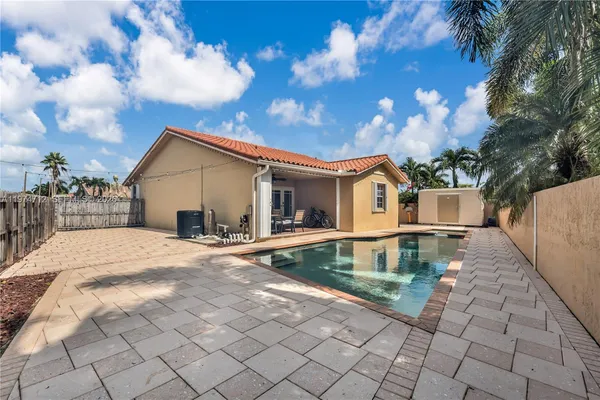 a view of a house with a yard and a large tree