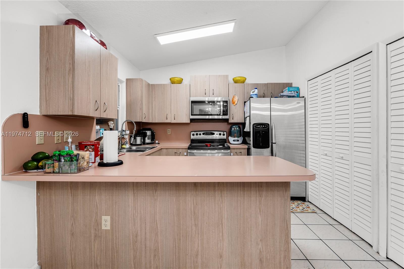12775 Southwest 59th Street Miami, FL 33183 - Photo 9 of 18 a kitchen with kitchen island granite countertop a sink a stove and a refrigerator