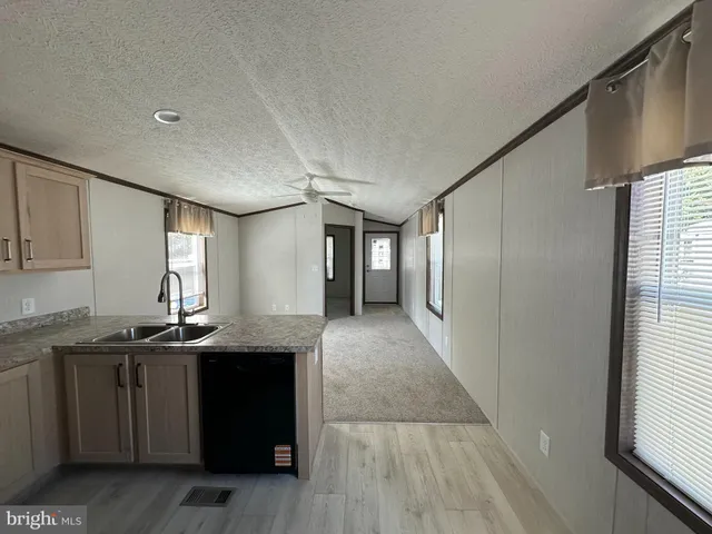 a kitchen with granite countertop a sink and cabinets