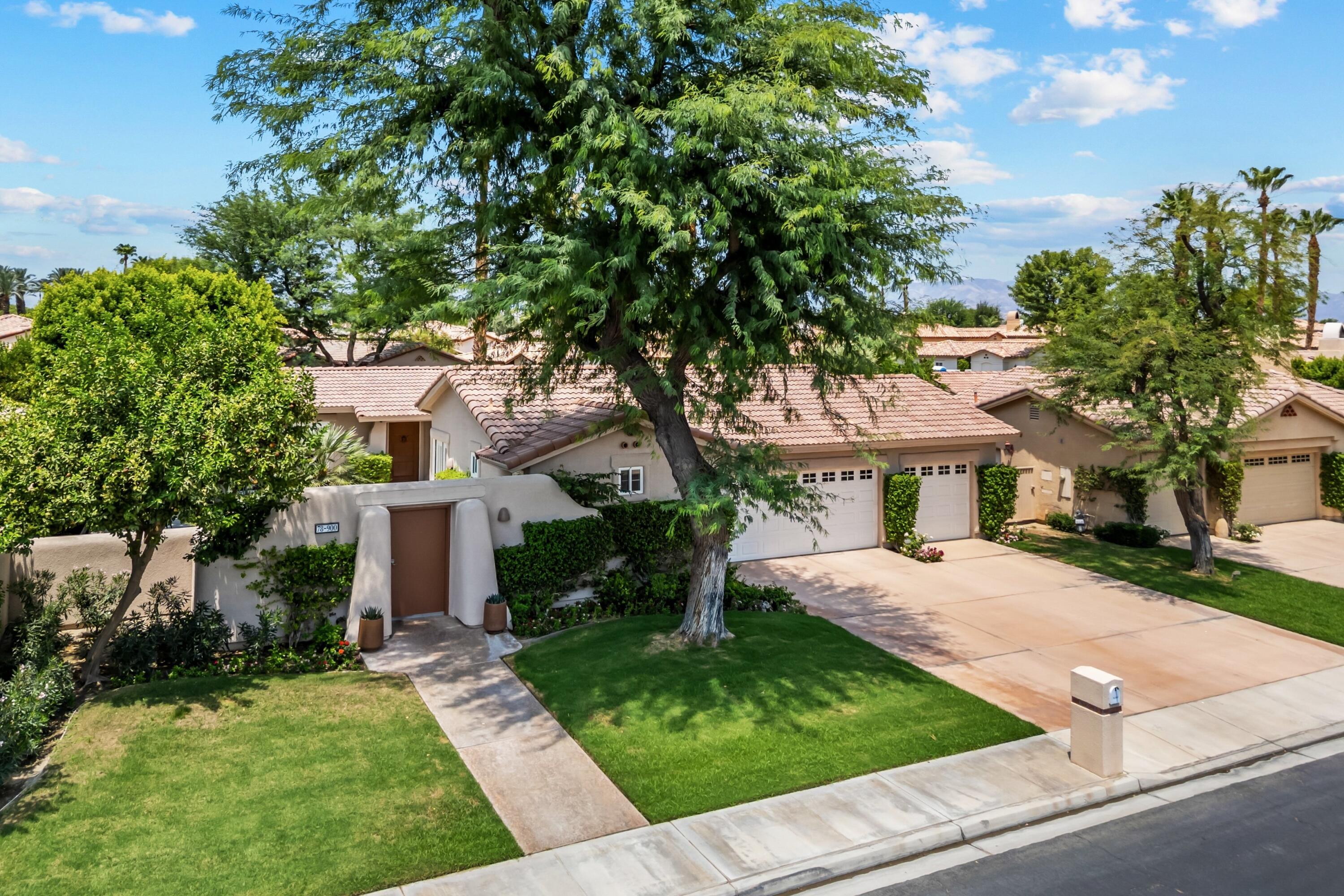 a front view of a house with a yard and trees