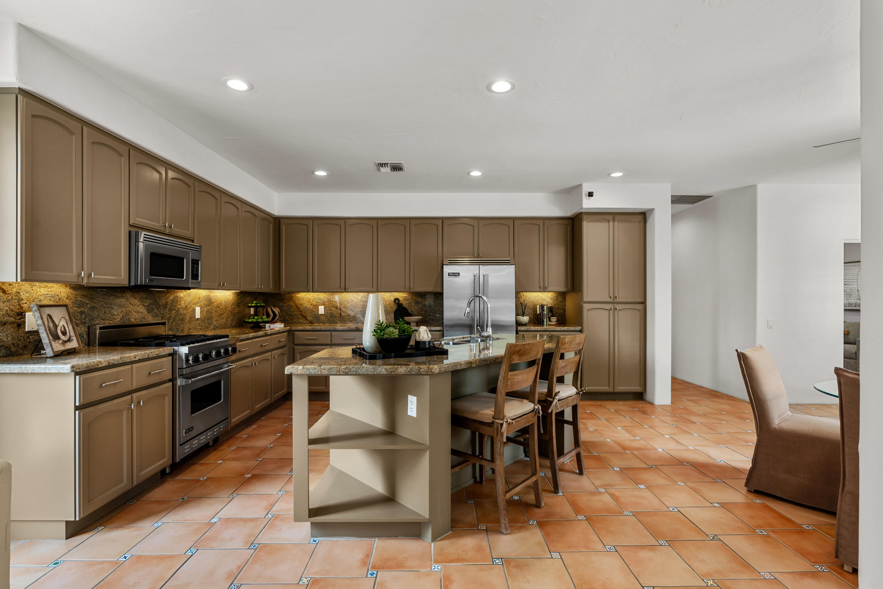 78900 Rio Seco La Quinta, CA 92253 - Photo 13 of 48 a kitchen with stainless steel appliances granite countertop a sink a stove a dining table and chairs