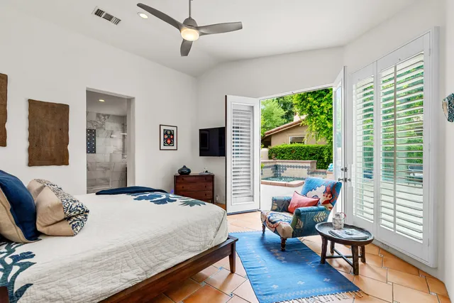 a bedroom with a bed and large windows