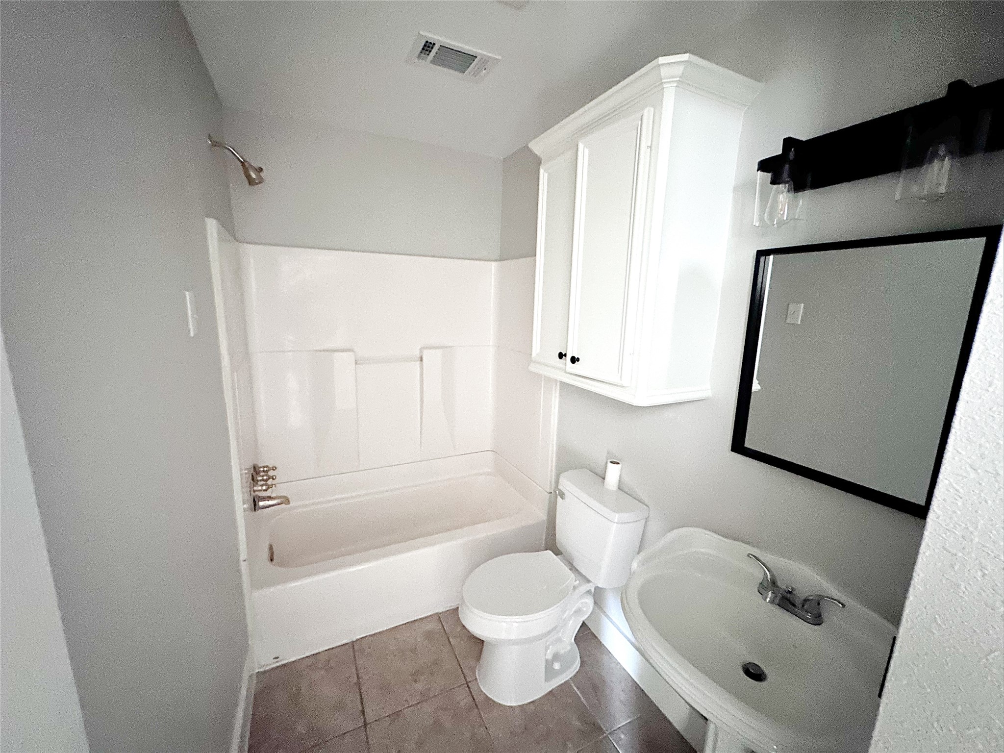 2324 Peppermill Road Houston, TX 77080 - Photo 12 of 20 Fullnbbathroom featuring a shower-tub combo, modern fixtures, and ample storage.