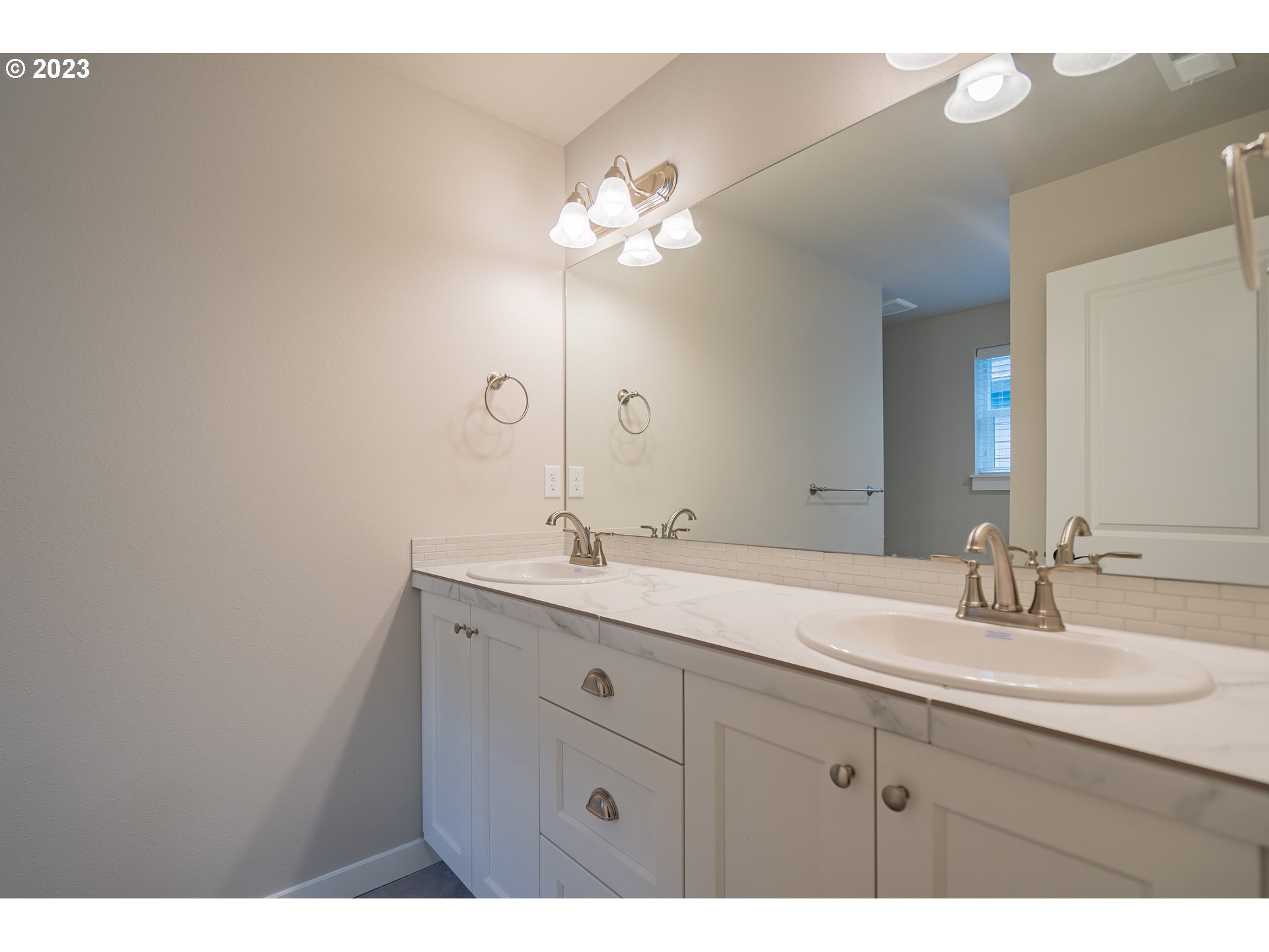 7049 South 13th Street Ridgefield, WA 98642 - Photo 8 of 33 a bathroom with a double vanity sink and a mirror