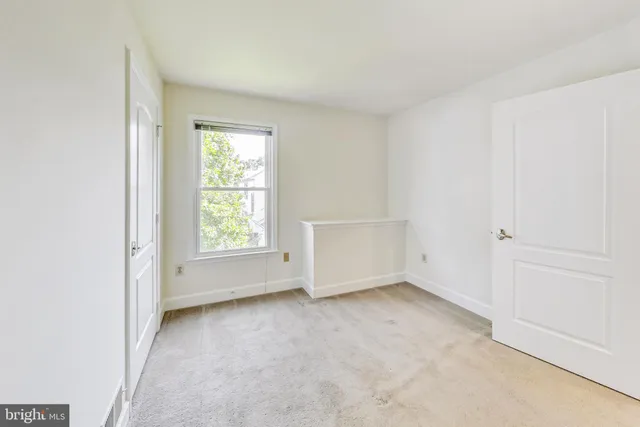 an empty room with white wall and closet