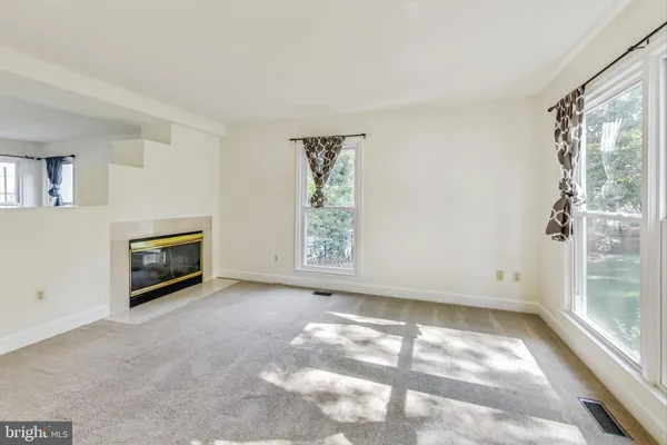 a view of a big room with windows and a fireplace