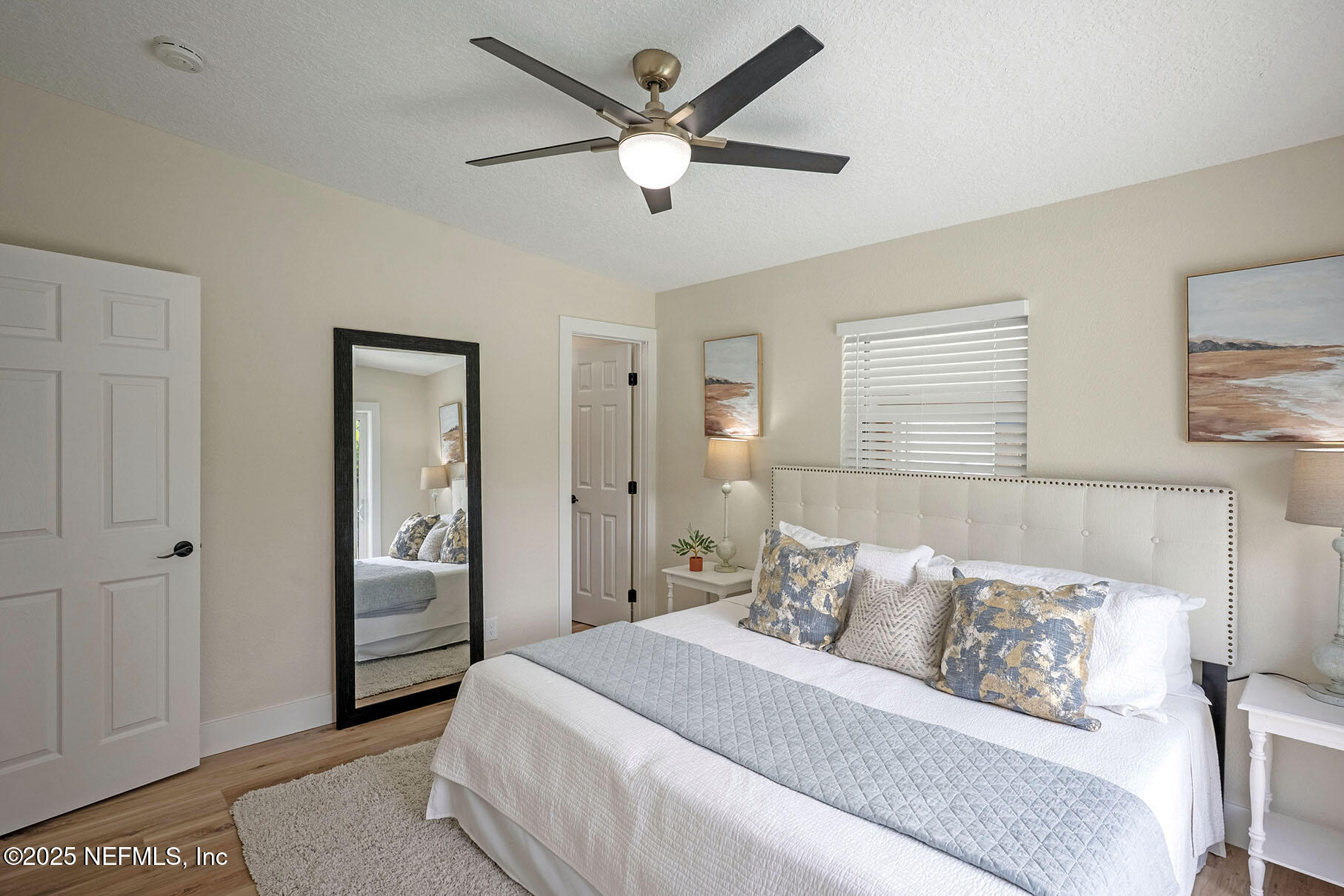 571 Hopkins Street Neptune Beach, FL 32266 - Photo 36 of 63 a bedroom with a large bed and a chandelier