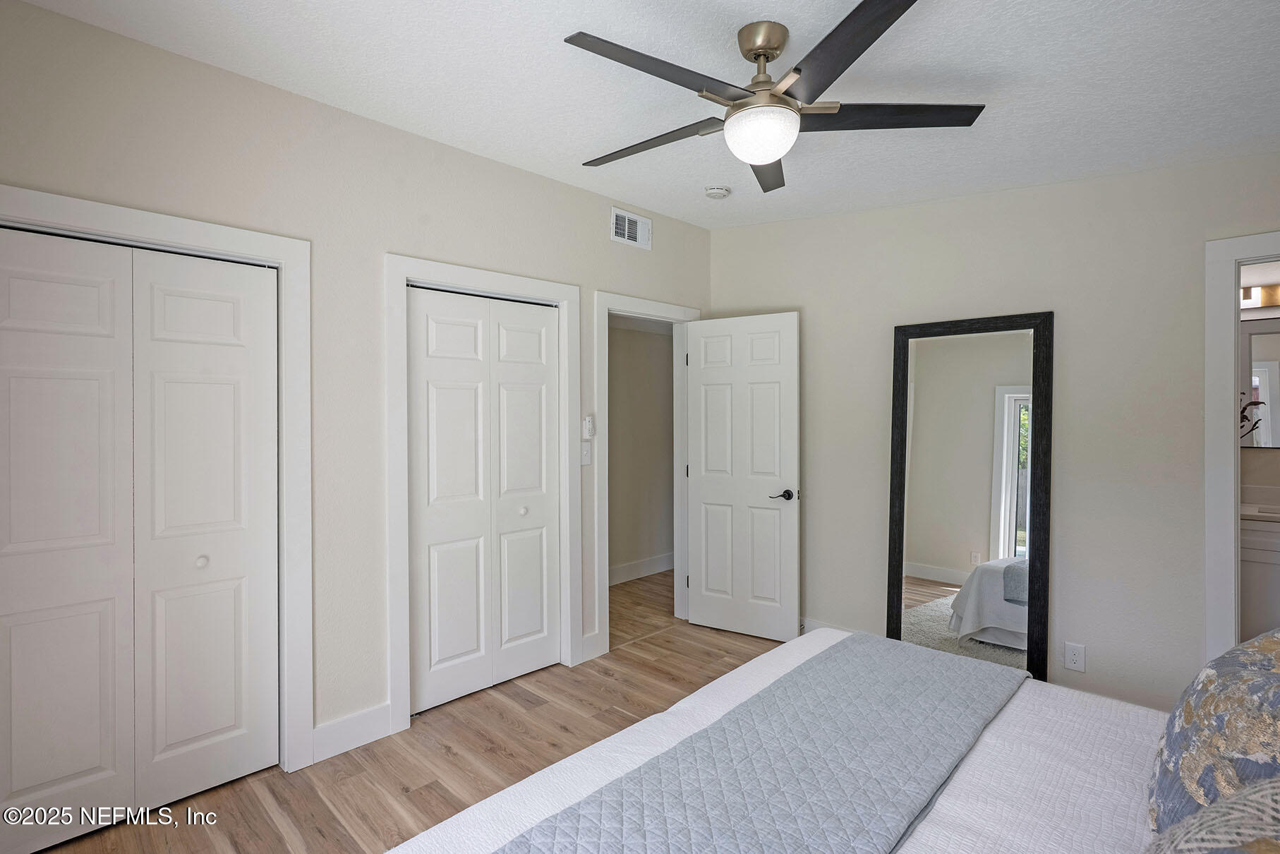 571 Hopkins Street Neptune Beach, FL 32266 - Photo 38 of 63 a bedroom with a large bed and a chandelier