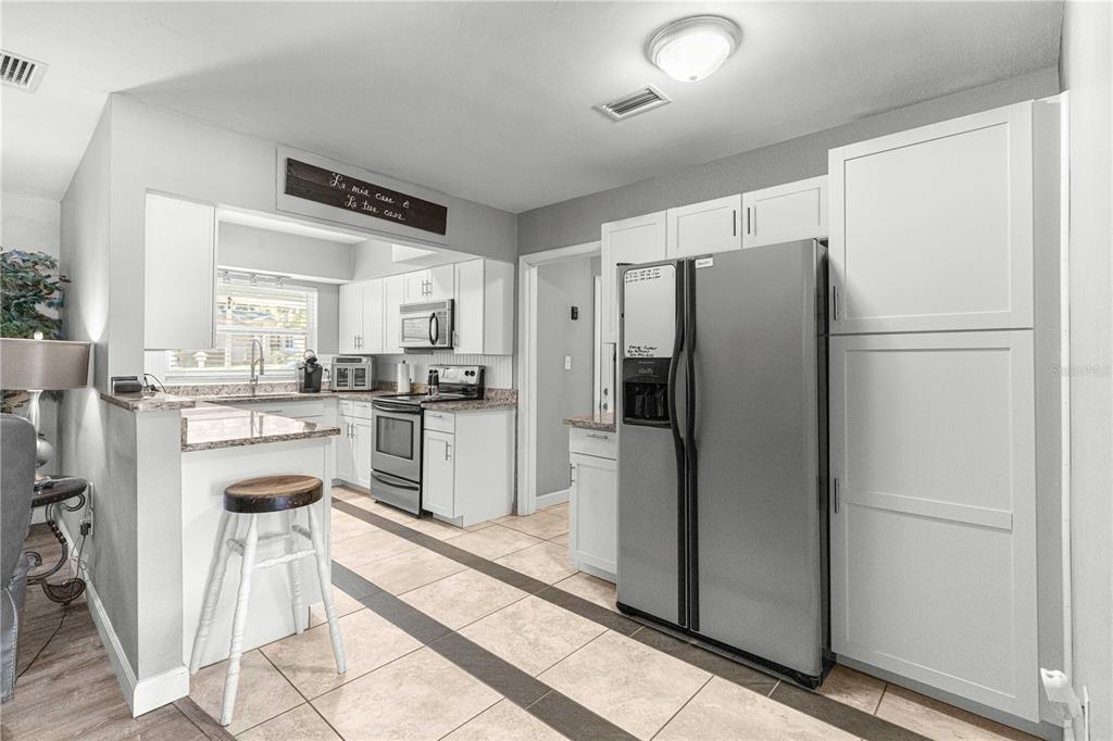 6401 East Holly Street Inverness, FL 34452 - Photo 11 of 51 a kitchen with white cabinets and stainless steel appliances