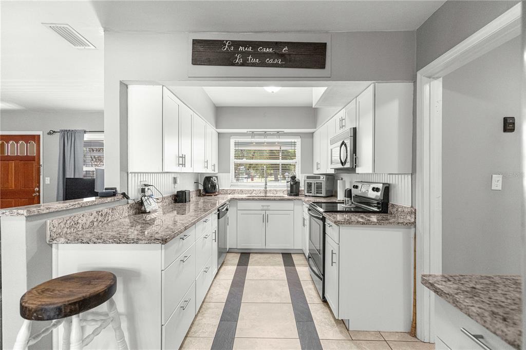 6401 East Holly Street Inverness, FL 34452 - Photo 12 of 51 a kitchen with stainless steel appliances granite countertop a sink stove and refrigerator