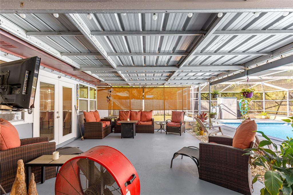 6401 East Holly Street Inverness, FL 34452 - Photo 30 of 51 a living room with furniture floor to ceiling window and a flat screen tv