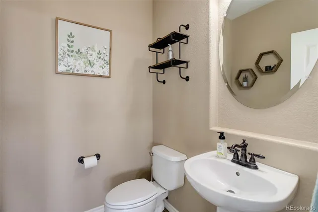 a bathroom with a toilet a sink and mirror