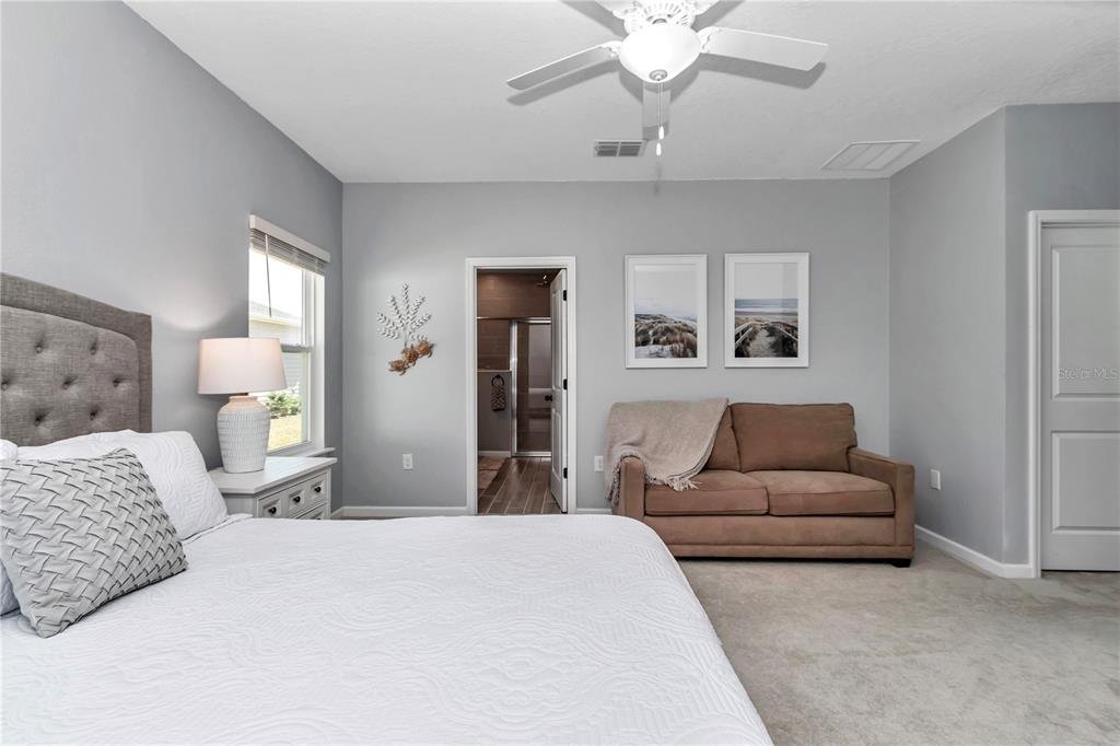 7651 Southwest 74th Loop Ocala, FL 34481 - Photo 13 of 47 a bedroom with a large bed couch and dresser