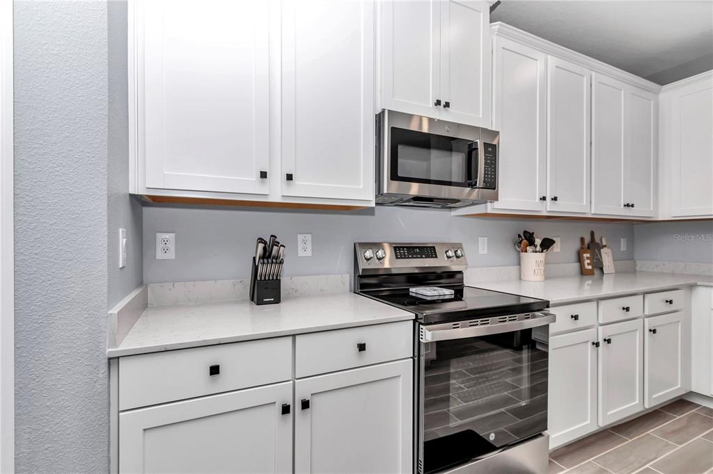 7651 Southwest 74th Loop Ocala, FL 34481 - Photo 39 of 47 a kitchen with stainless steel appliances granite countertop white cabinets and a stove a oven with white countertops