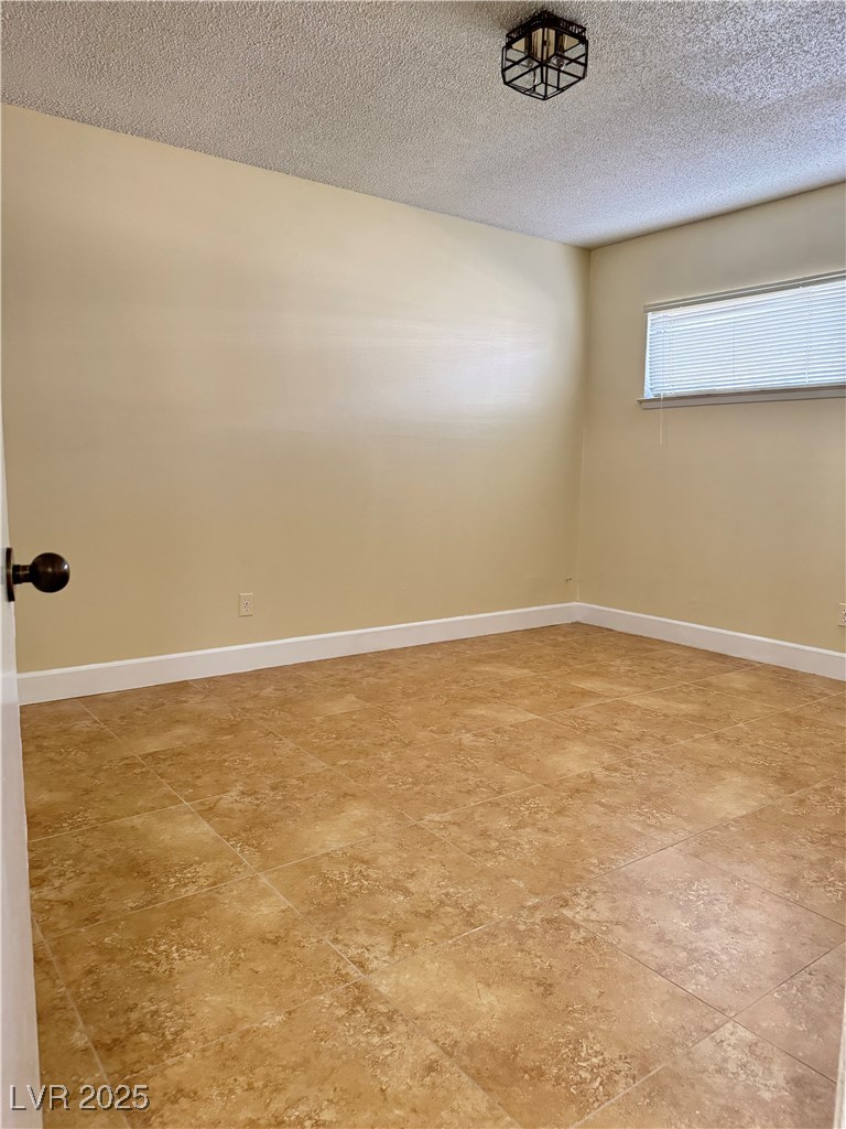 350 East Desert Inn Road, Unit F104 Las Vegas, NV 89109 - Photo 11 of 27 Spare room with a textured ceiling and baseboards
