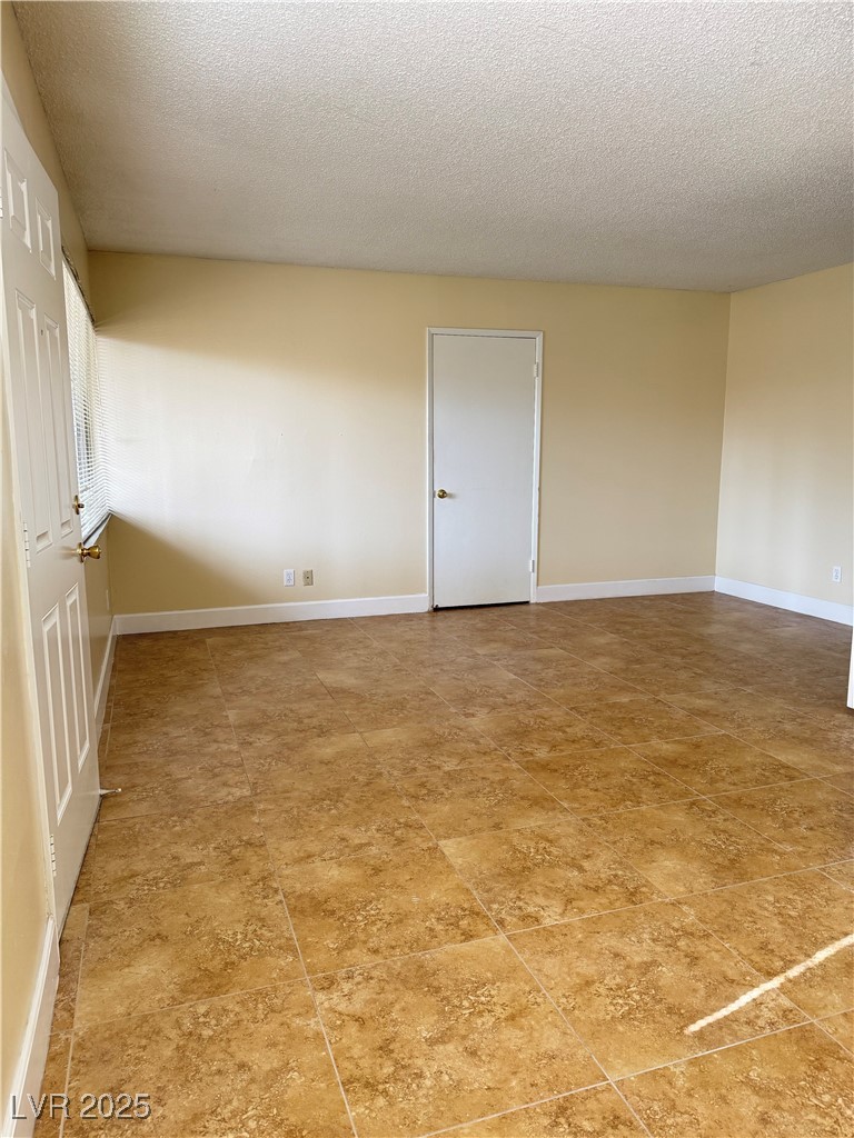 350 East Desert Inn Road, Unit F104 Las Vegas, NV 89109 - Photo 12 of 27 Spare room with a textured ceiling and baseboards