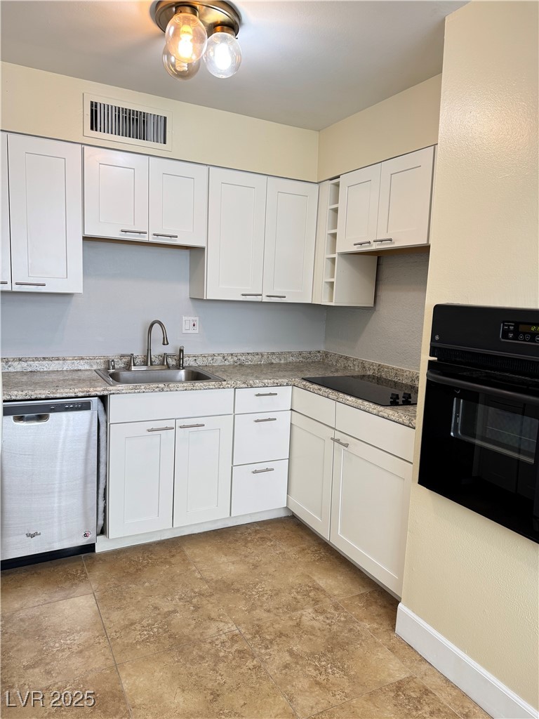 350 East Desert Inn Road, Unit F104 Las Vegas, NV 89109 - Photo 3 of 27 Kitchen with black appliances, open shelves, white cabinetry, and light countertops