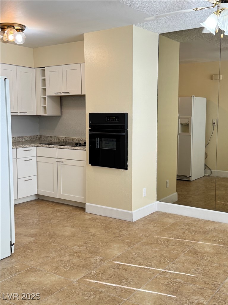 350 East Desert Inn Road, Unit F104 Las Vegas, NV 89109 - Photo 5 of 27 Kitchen featuring black appliances, dark countertops, white cabinets, and open shelves