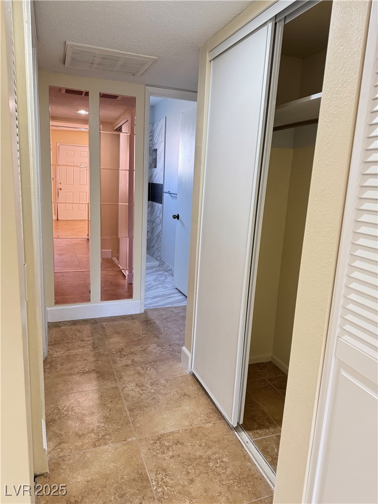 350 East Desert Inn Road, Unit F104 Las Vegas, NV 89109 - Photo 10 of 27 Hallway featuring a textured ceiling