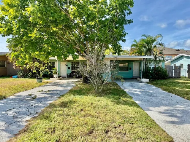 a view of yellow house with swimming pool lawn chairs and next to a yard