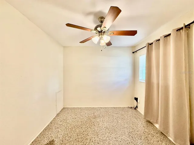 a view of a hallway with a window and a ceiling fan
