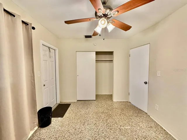 a view of a bedroom with a ceiling fan