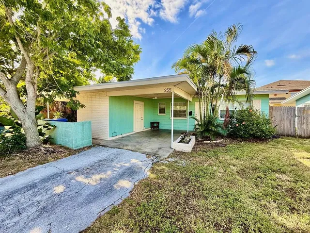 a view of a house with backyard and a tree