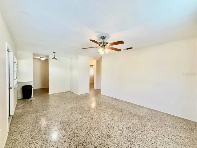 a view of a livingroom with a ceiling fan and hardwood floor