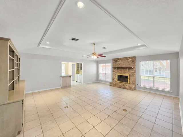 an empty room with fireplace and windows