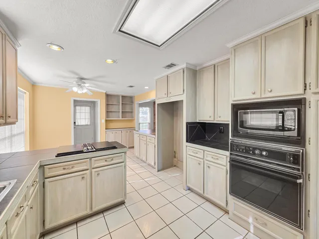 a kitchen with white cabinets and appliances
