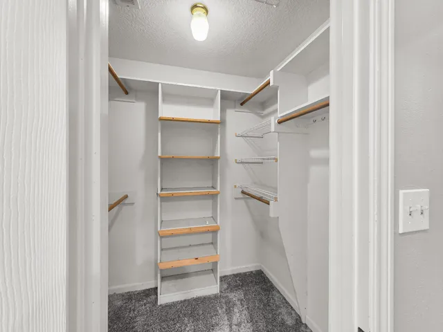 a view of walk in closet with empty racks