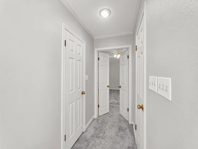 a view of an empty room with a chandelier fan
