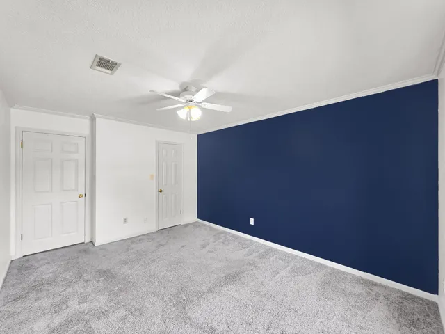 a view of an empty room with a chandelier fan