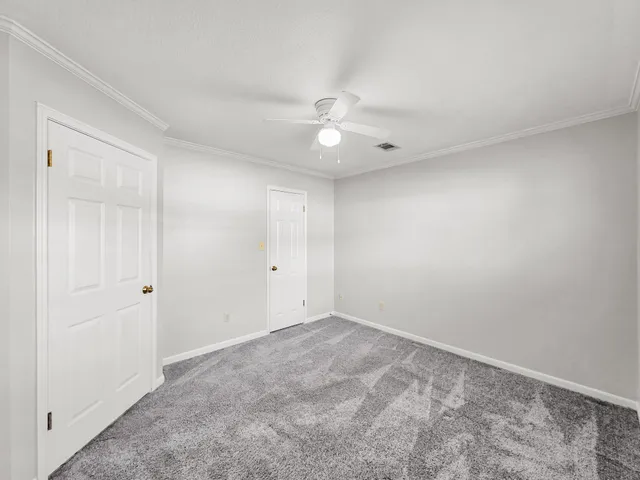 an empty room with a window and ceiling fan