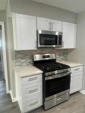 a kitchen with granite countertop a stove and a microwave