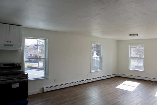 118 South Main Street, Unit 2 Freetown, MA 02702 - Photo 6 of 16 an empty room with wooden floor cabinet and windows