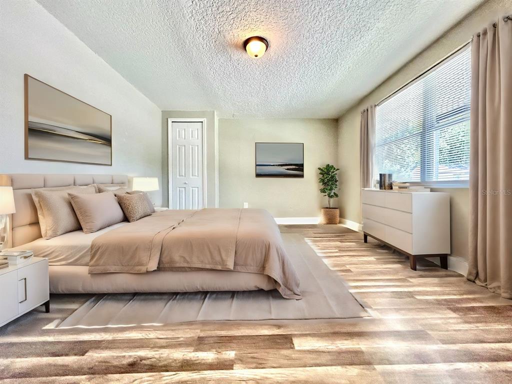 418 Charles Street Winter Garden, FL 34787 - Photo 11 of 27 a spacious bedroom with a bed a couch and large window