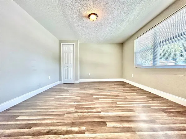 a view of a room with wooden floor and window