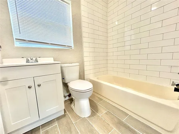 a bathroom with a toilet a sink a mirror and bathtub